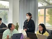 桌子上放着笔记本电脑的人们 中度可信度描述已自动生成